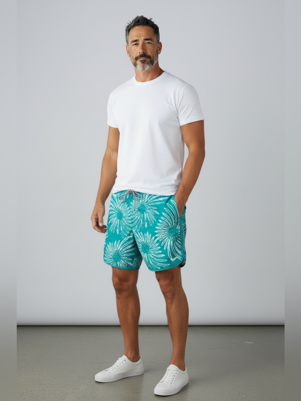 Speedo men's swim shorts with white floral pattern on teal background, size XL